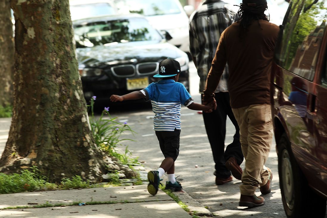 A child walks with an adult in East New York